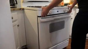 Homeowner inspecting a white gas range oven in a Lexington KY kitchen