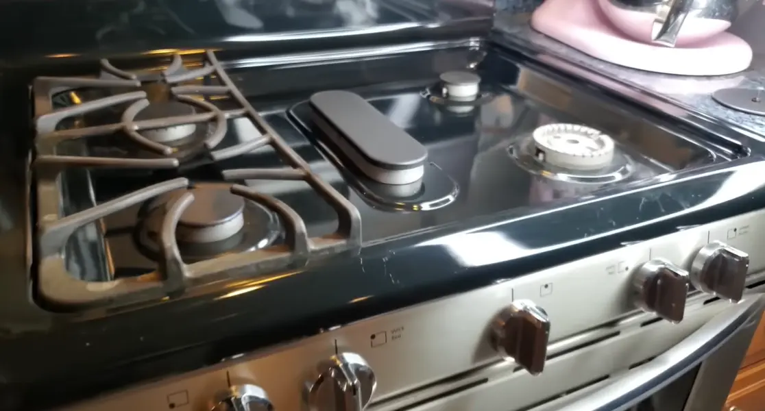 Close-up of gas stove burners and control knobs showing wear on a stove needing repair in Lexington KY